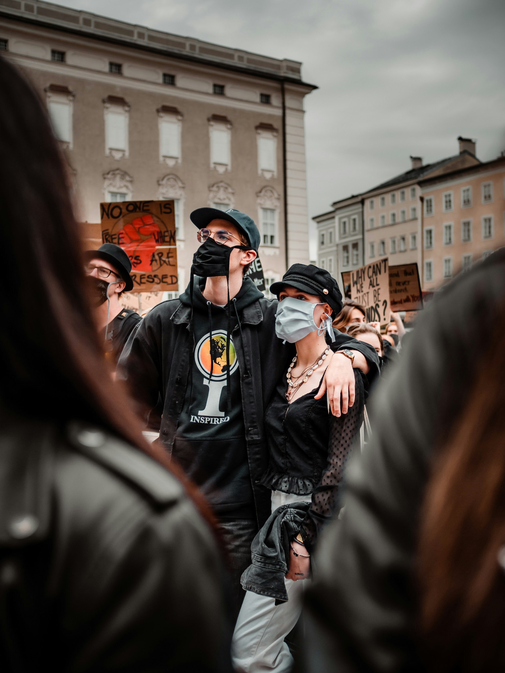 people in black jacket standing near brown concrete building during daytime